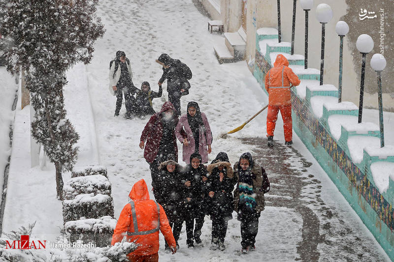 کارگران شهرداری که مشغول برف روبی هستند.