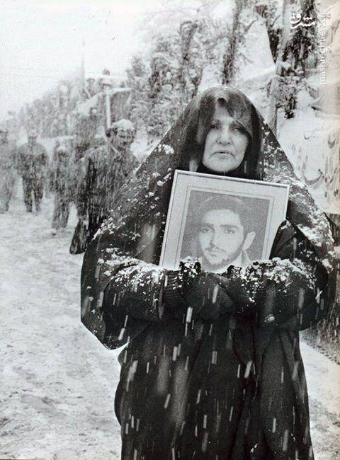 مادر شهید شاهین باقری نیا به همراه عکس فرزندش در هوای برفی