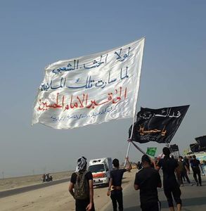 نوشته روی پرچم (اگر حشد شعبی نبود جمعیت میلیونی نمیتوانست به سمت ضریح امام حسین حرکت کند)