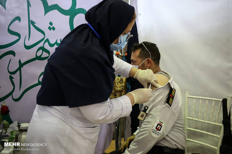 تزریق واکسن به یکی از کارکنان سازمان آتش نشانی تهران در مرکز واکسیناسیون بوستان بعثت