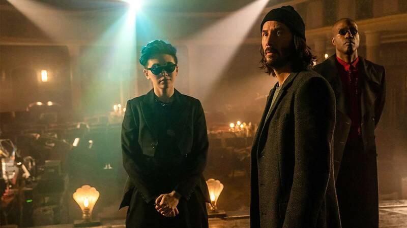کیانو ریوز در نقش نئو حال تماشا خاطرات گذشته‌اش درکنار مورفیوس و باگز در فیلم The Matrix Resurrections