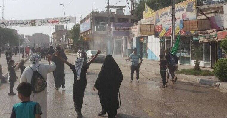 عکس | آب پاشی کوفیان به روی زائران | موکب های « کوفه» خلوت تر است