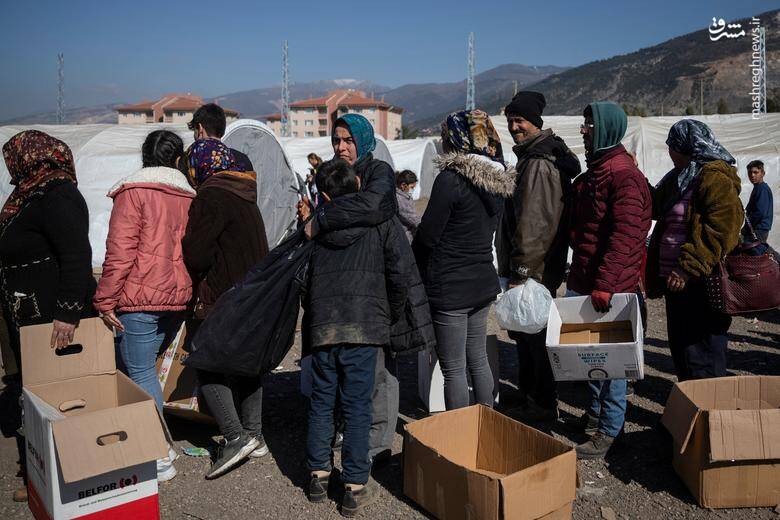 زلزله زدگان آواره شده در صف برای کالاهای اهدایی در اردوگاهی در اسکندرون، ترکیه
