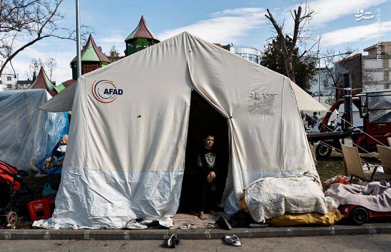 پسر یک پناهجوی سوری، محمد الکاشف، پس از فروریختن خانه‌اش در اثر زلزله در آدیامان، ترکیه در ورودی یک چادر، جایی که محمد با خانواده‌اش در یک زمین پارک عمومی زندگی می‌کند، ایستاده است. 