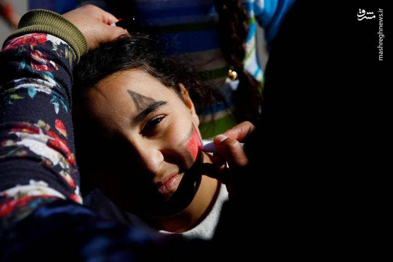 زنی در حین فعالیت برای سرگرمی و حمایت از سلامت روان کودکان آسیب دیده از زلزله در  ترکیه، صورت دختری را نقاشی می کند. 