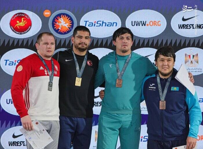 قهرمان کشتی ترکیه با لباس مشکی روی سکو +عکس