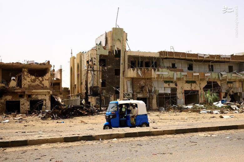 عبور یک خودرو از کنار ساختمان‌های تخریب شده در جریان درگیری بین نیروهای پشتیبانی سریع شبه نظامی و ارتش در شمال خارطوم _ سودان