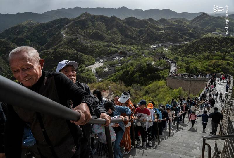 مردم در اولین روز از تعطیلات روز کارگر از پلکانی روی دیوار بزرگ چین در پکن بالا می‌روند.