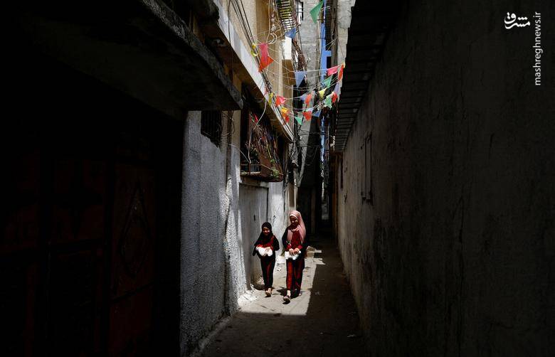 قدم زدن دو دختر فلسطینی در روز جهانی پناهندگان در شهر غزه در اردوگاه پناهندگان الشاطی