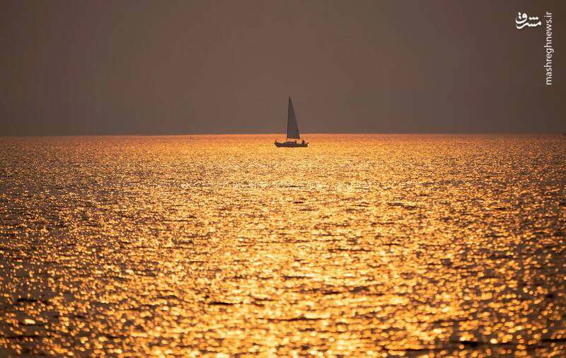 تصویری زیبا از غروب خورشید و عبور یک قایق بادبانی در اتاوا _ کانادا