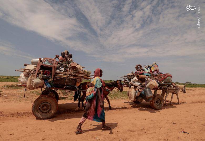 یک زن سودانی با وسایل خود از مرز بین سودان و چاد عبور می‌کند.
