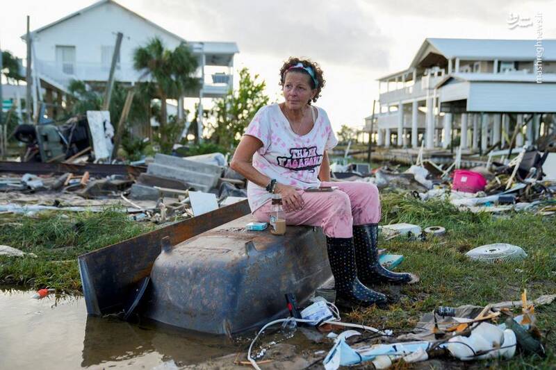 یک زن میانسال در میان ویرانه‌های خانه‌اش که بر اثر طوفان تخریب شده در فلوریدا _ آمریکا