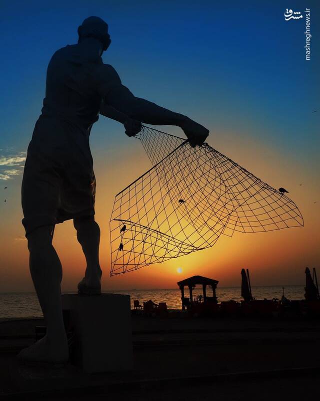 نمایی جالب از مجسمه مرد ماهیگیر در کیش
