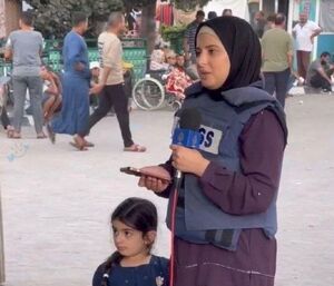 تصویری از خبرنگاری که به همراه دختر کوچکش اخبار را مخابره می‌کند