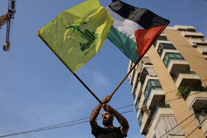 مردی با پرچم‌های حزب‌الله و فلسطین - نمایه