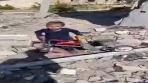 فیلم/ تلاش پسربچه فلسطینی برای بیرون آوردن سه چرخه اش از زیر آوار خانه شان