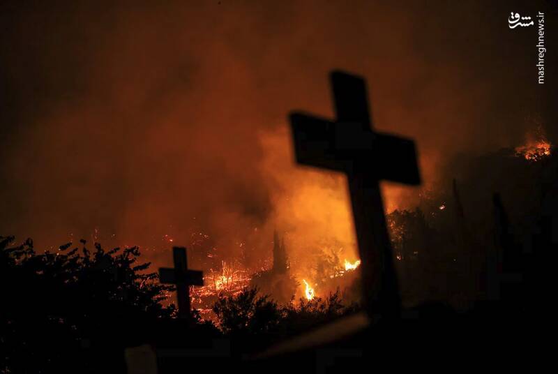 تصویری از آتش‌سوزی جنگلی و صلیب‌های قبرها در روستای لاتاس، یونان