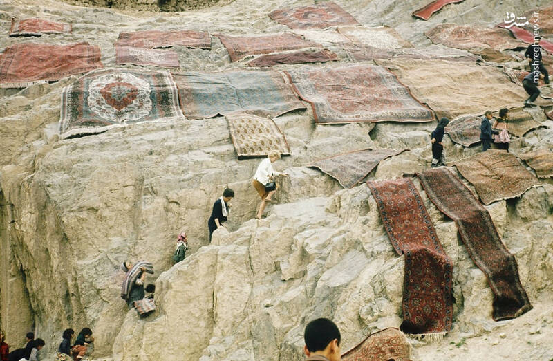 تصاویری از خشک کردن فرشهای ایرانی بر روی تپهٔ سنگی چشمهعلی ۶۴ سال پیش
