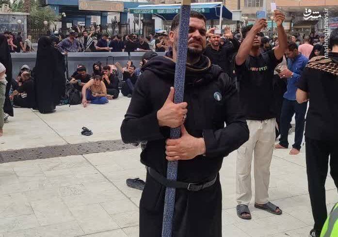 تصویر رهبر انقلاب در دست جوان عراقی مقابل حرم سقا