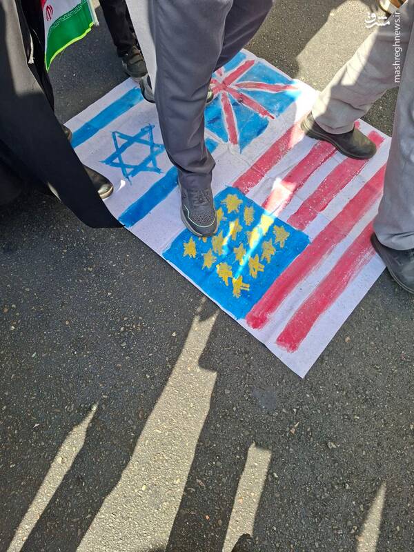 پیاده روی شرکت کنندگان در راهپیمایی بر روی پرچم‌های امریکا و اسرائیل