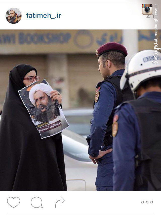 عکس/ اعتراض زن بحرینی به سربازان آل خلیفه با پوستر «شیخ نمر»
