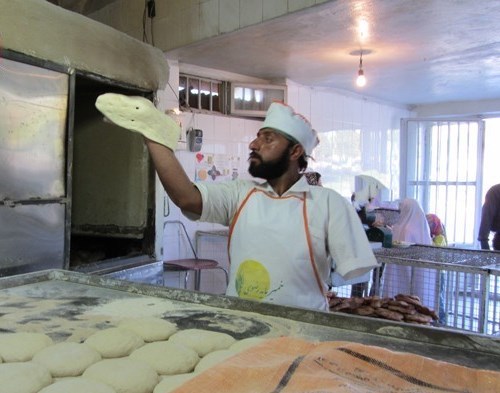 نانوای که با یک دست نان سر سفره مردم می‌گذارد +عکس